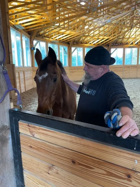 A resident bonding with a horse during equine therapy